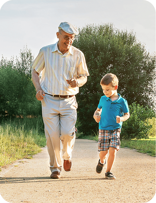 Älterer Mann spaziert mit kleinem Jungen im Park